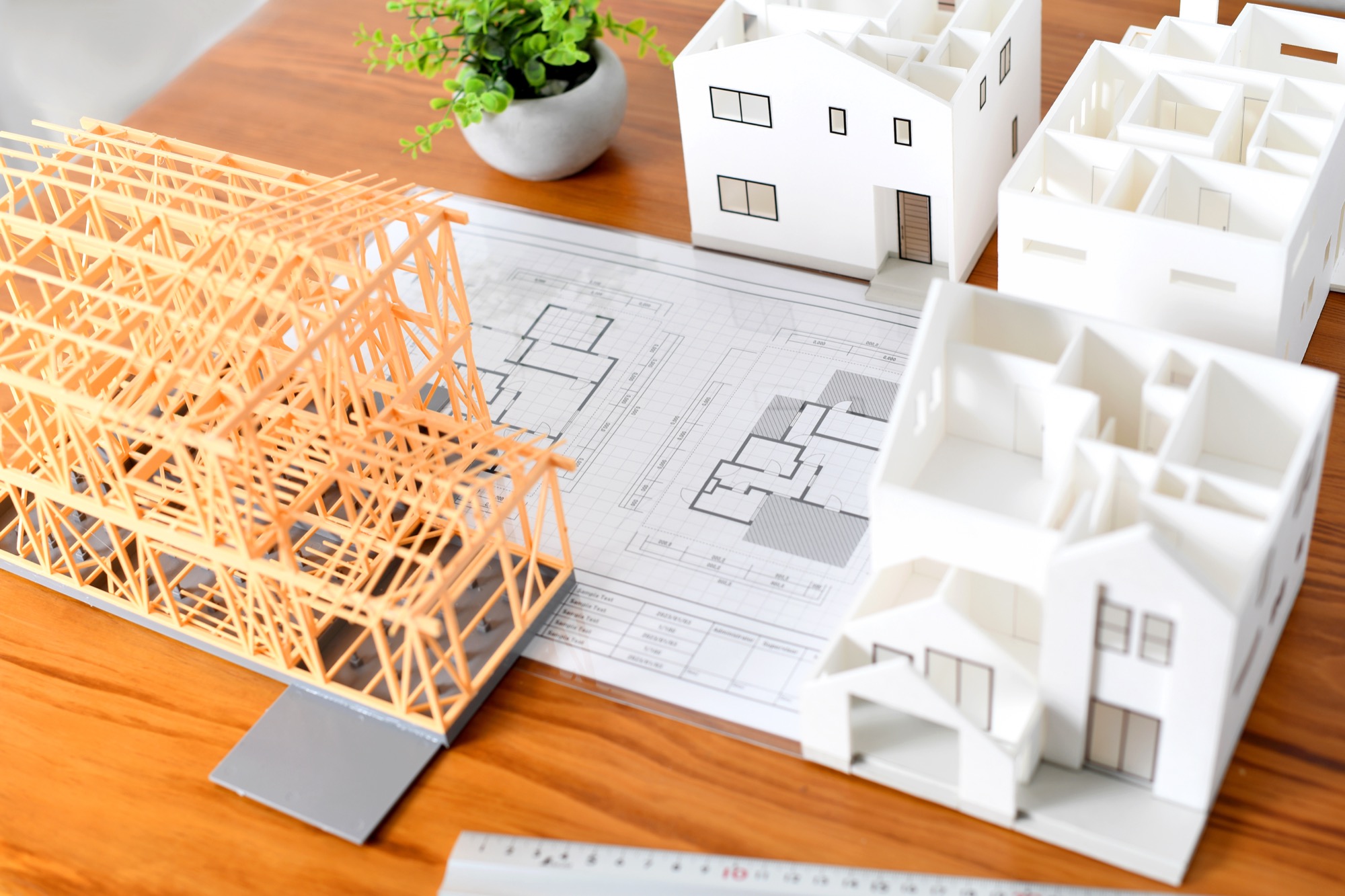 テーブルに置かれた住宅模型と構造模型、間取り図